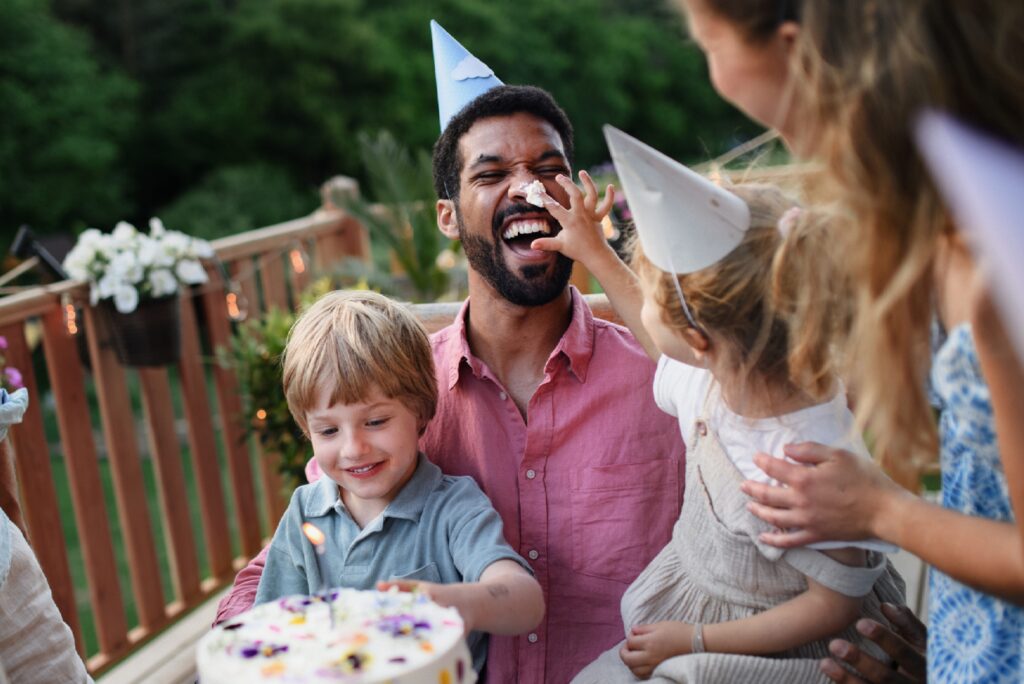 Uncle with birthday cake and party hats