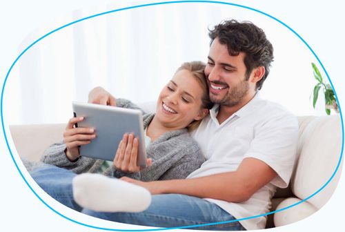 Couple together on couch looking at ipad