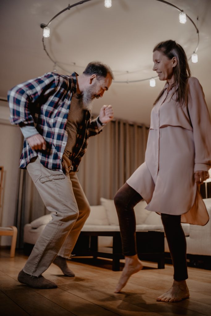 Older retired couple dancing in living room